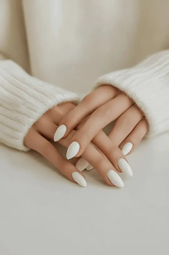 Hands with elegant white manicure resting on a table